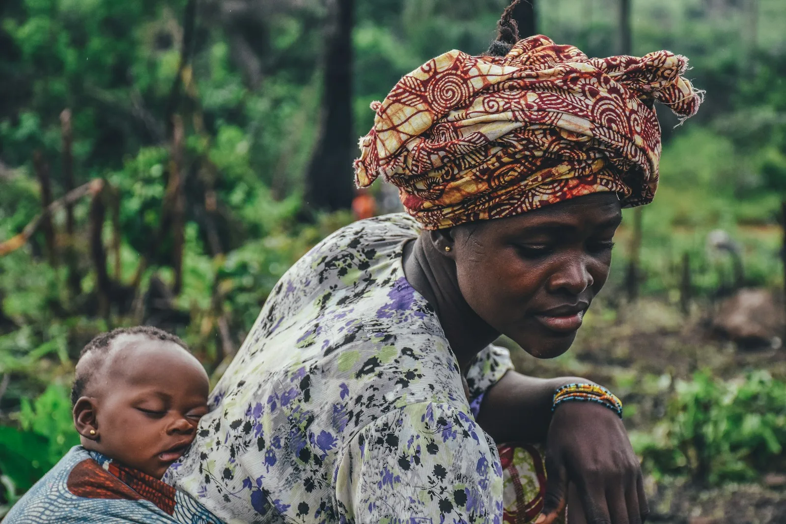 A woman carrying a baby on her back
