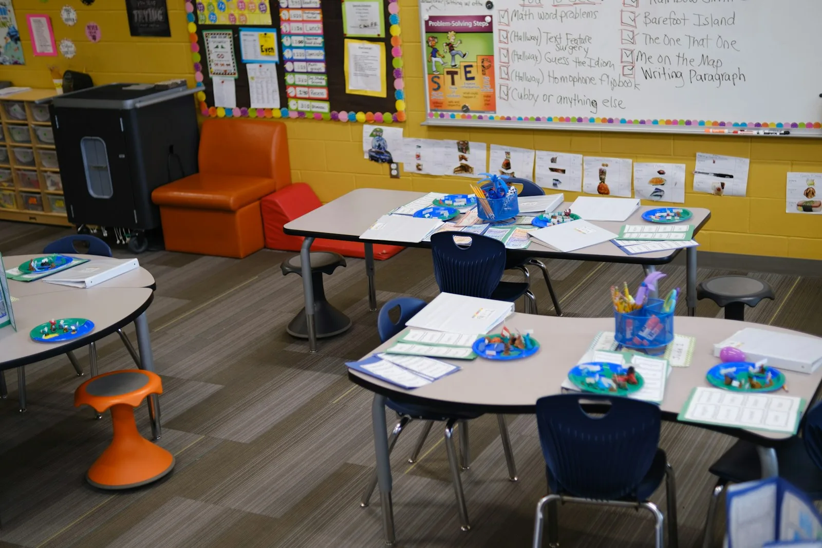A bright classroom with small tables and chairs