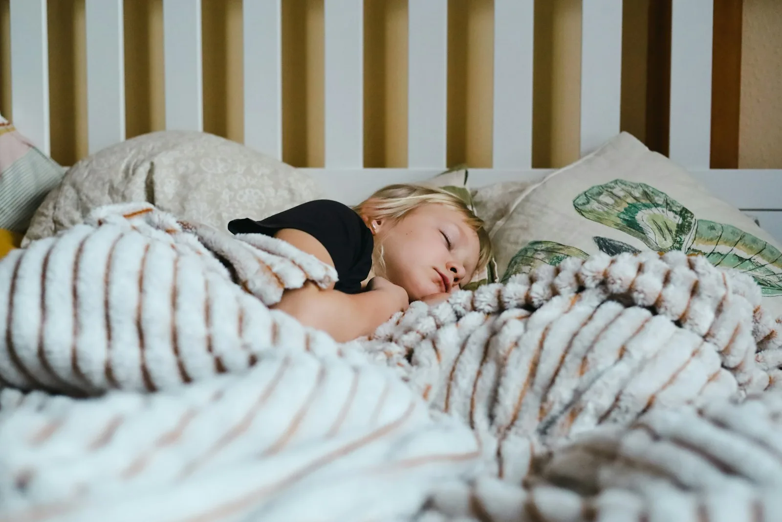 A little girl asleep under a blanket